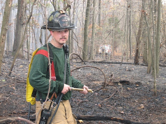 Firefighter Shawn Loomis using a "bladder bag" to put out spot fires